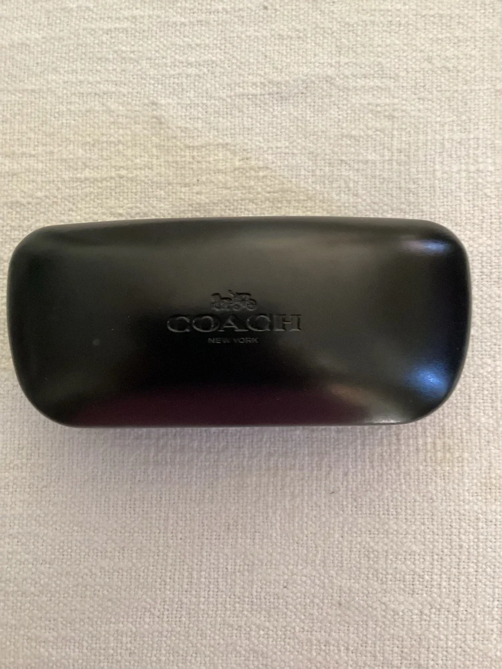 Black Coach New York branded hard-shell glasses case.